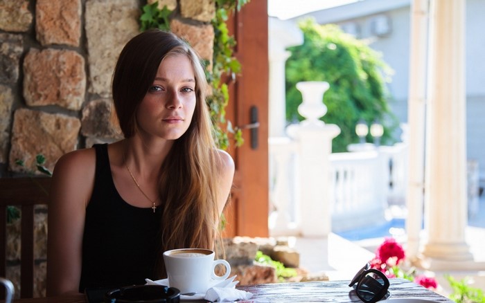 Woman with long auburn hair at a cafe