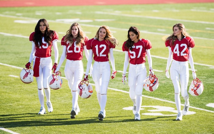 Models in American football uniforms on a field