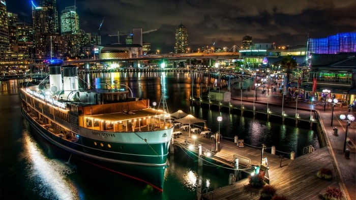 Sydney Harbour at night with illuminated ship and cityscape