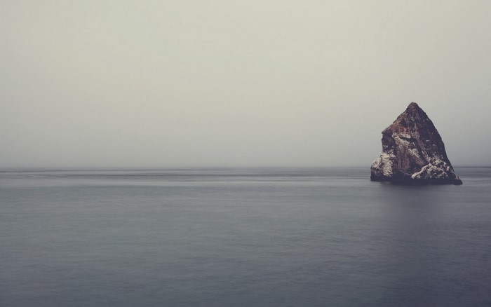 Rock formation in the sea with fog