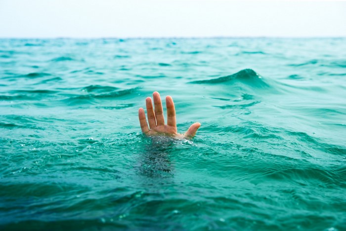 Hand reaching out of the ocean