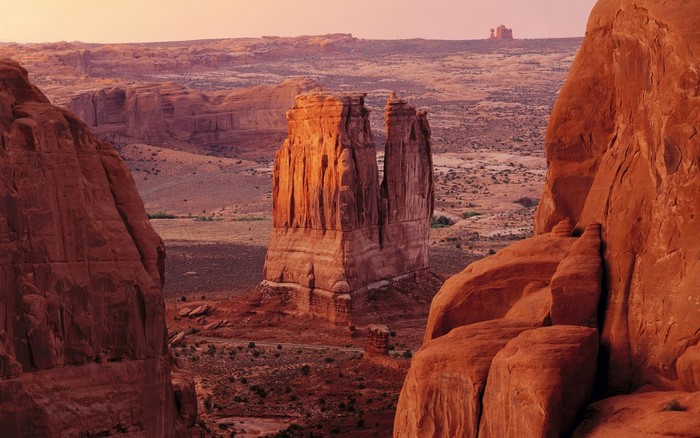 Desert landscape with rock formations and mesas at sunset
