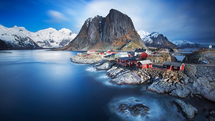 Red fishing cabins on a rocky shore in Norway