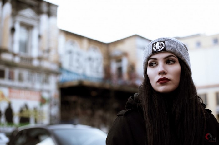 Woman wearing a beanie and jacket, looking away
