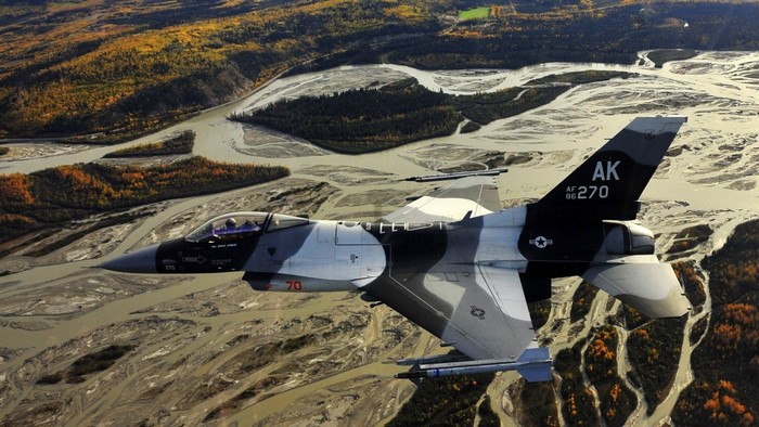 F-16 Fighting Falcon flying over Alaskan landscape