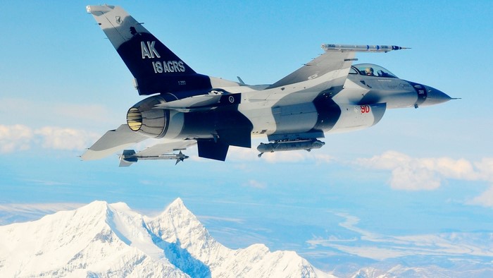 F-16 Fighting Falcon aircraft flying over mountains