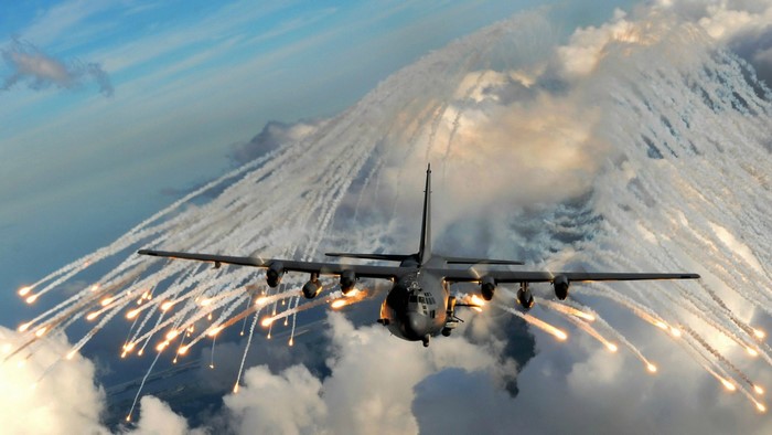AC-130 aircraft deploying flares in the sky