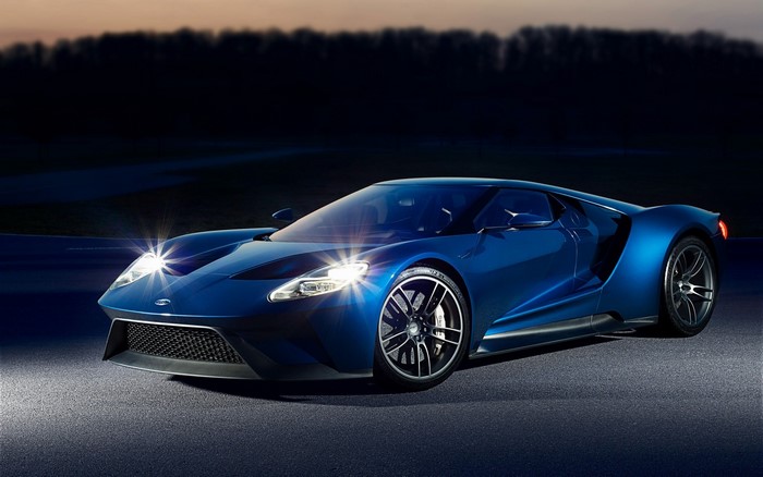 Blue Ford GT sports car on a dark road