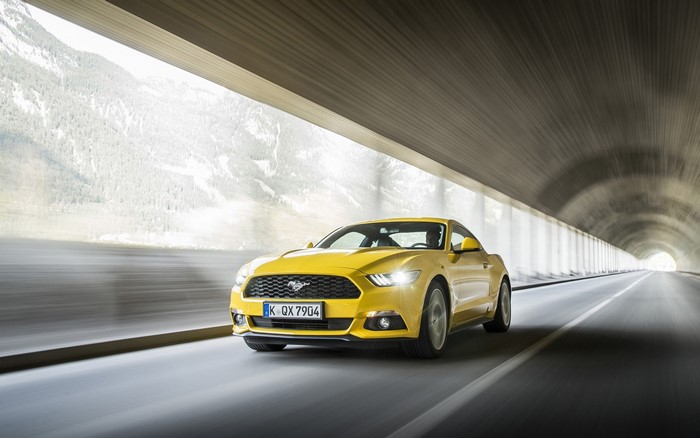 Yellow Ford Mustang GT driving out of a tunnel