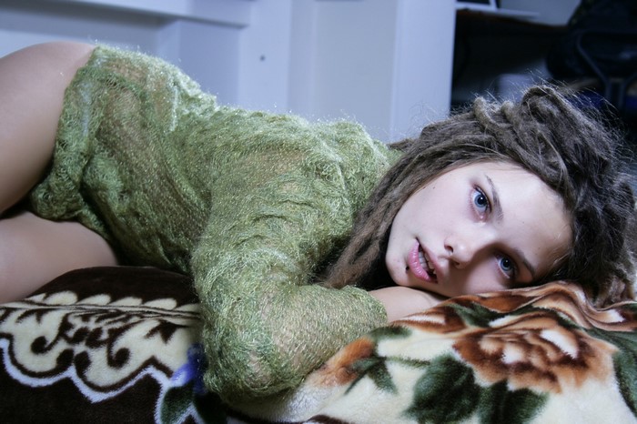Girl with dreadlocks wearing a green sweater