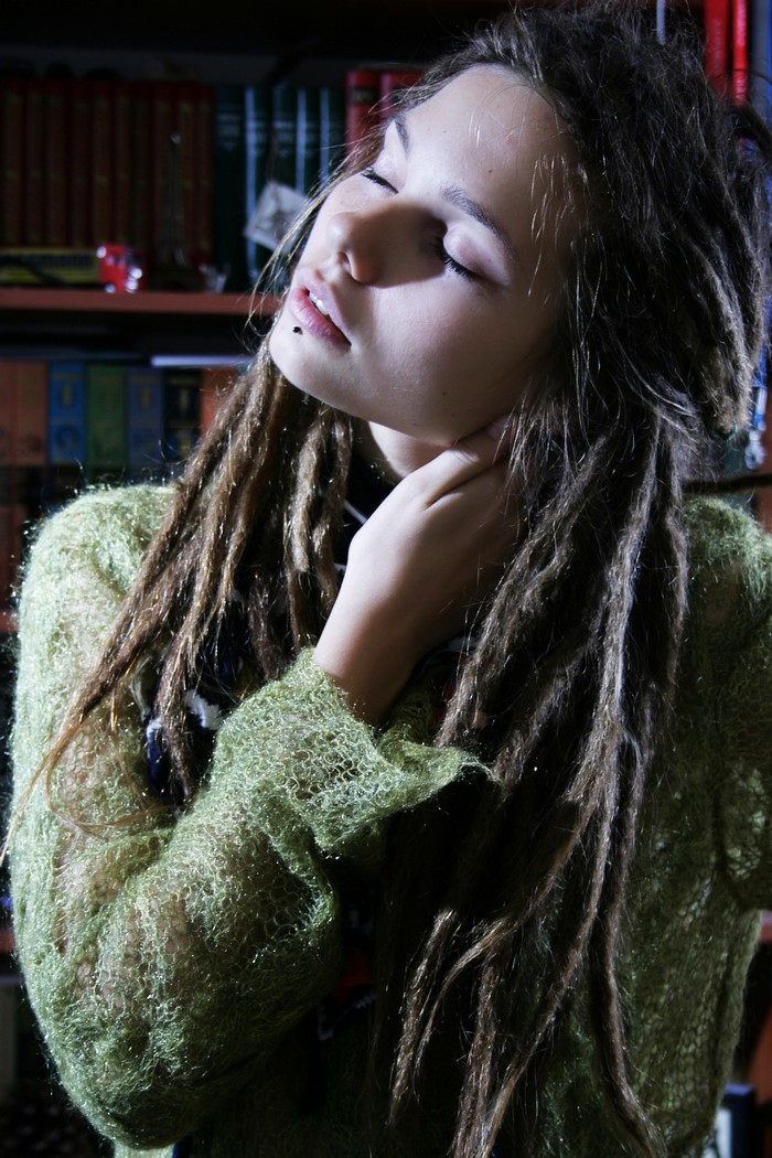 Woman with dreadlocks wearing a green sweater