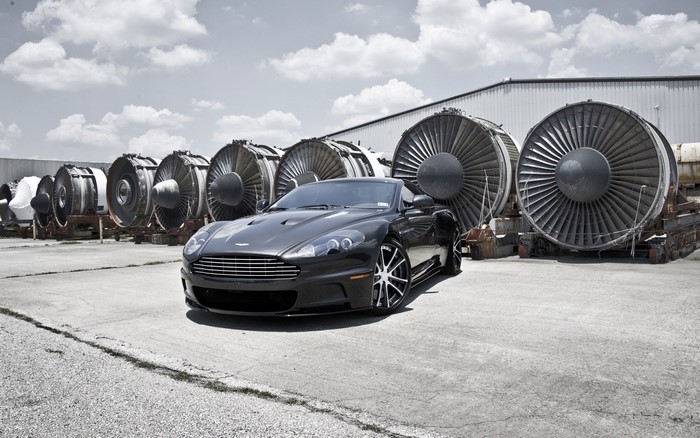 Aston Martin DBS convertible parked near jet engines