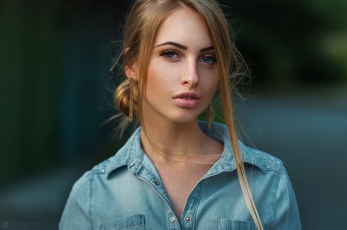 Woman with blond hair and blue eyes wearing a denim shirt