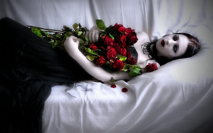 Gothic woman in black dress with red roses