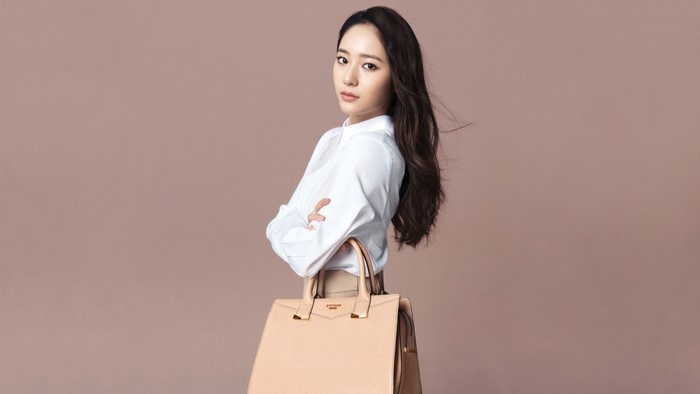 Asian model in white shirt with beige handbag