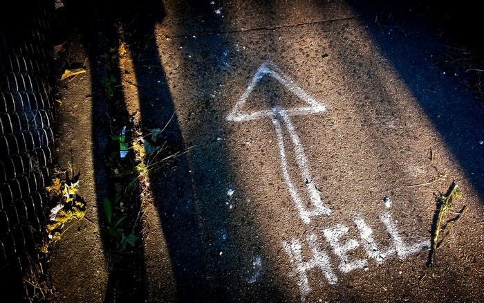 Arrow pointing to Hell on asphalt