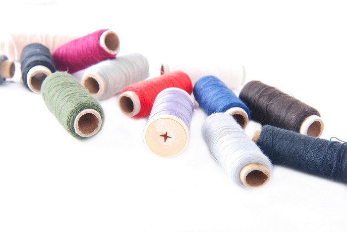Assortment of colorful thread spools on a white background