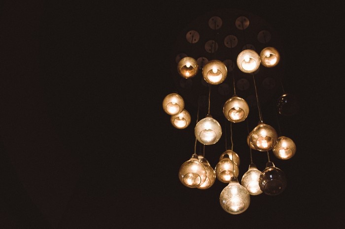 Chandelier with glass orb lights in darkness