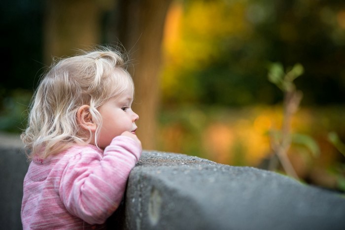 Baby girl in pink shirt looking away