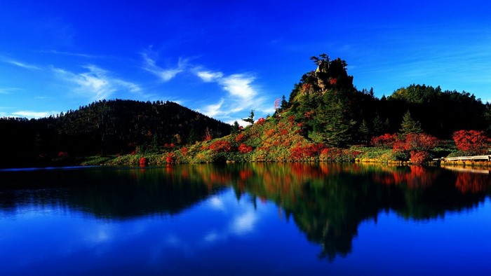 Autumn landscape with lake and colorful hills in Japan