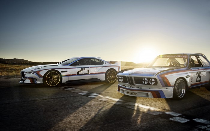 Two BMW 3.0 CSL race cars at sunset