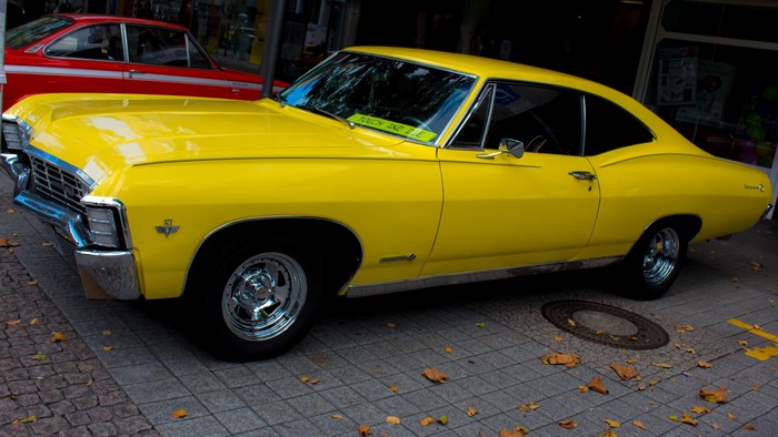 Yellow Chevrolet Impala SS parked on a cobblestone street