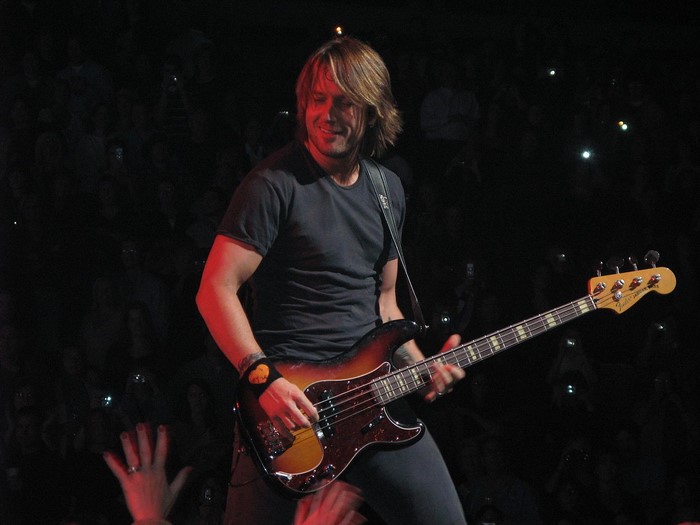 Keith Urban playing bass guitar on stage