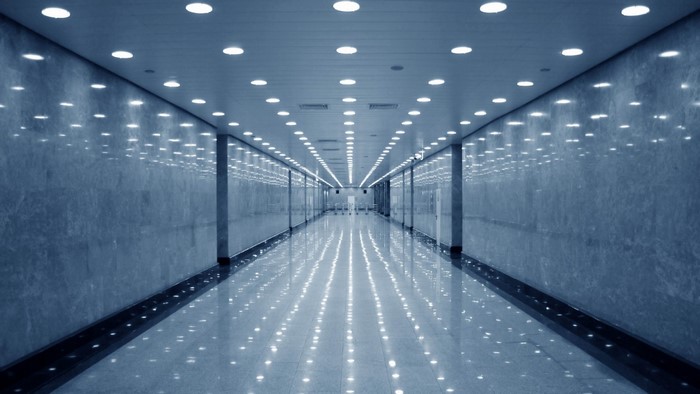 Modern marble hallway with ceiling lights and reflections