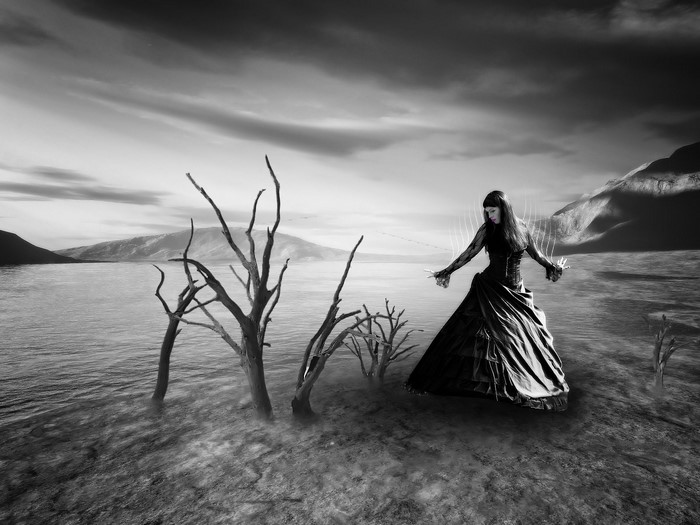 Monochrome fantasy art of a woman in a dark dress by the sea