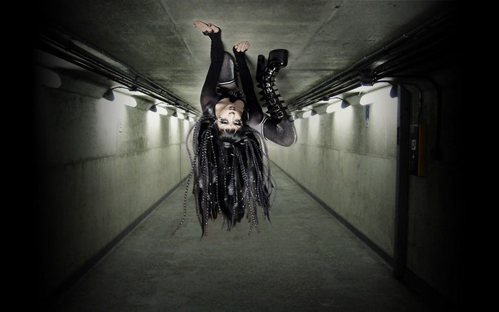 Woman with dreadlocks upside down in a tunnel
