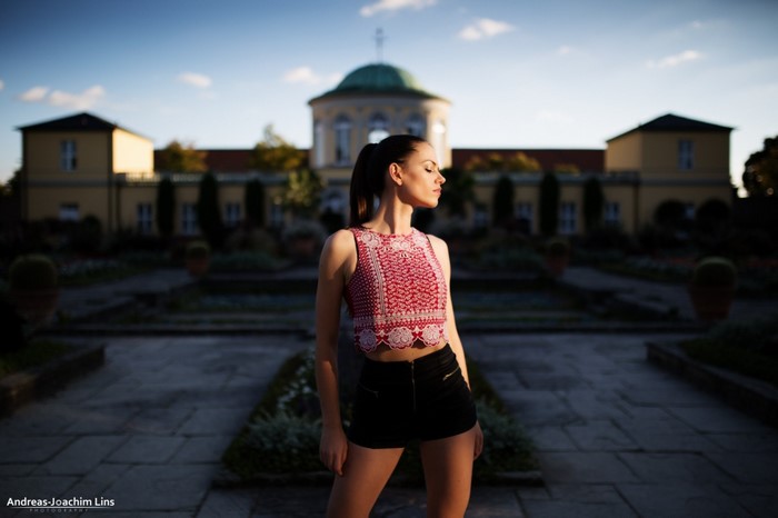 Woman in crop top and shorts posing in garden