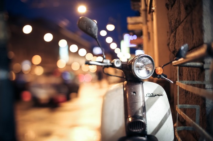 Scooter parked on a city street at night