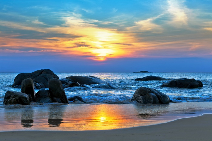 Sunset over the Pacific Ocean with stones on the shore