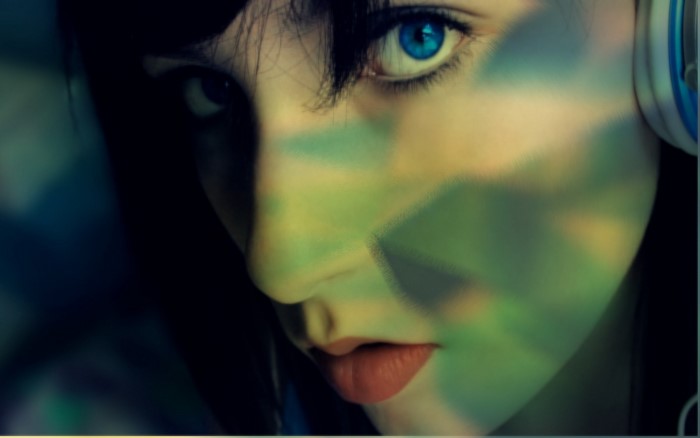 Close up of a person with blue eyes and headphones
