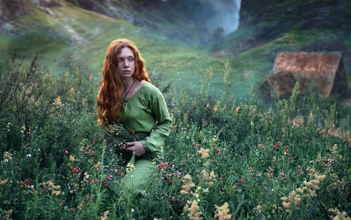 Redhead woman in green dress in a field