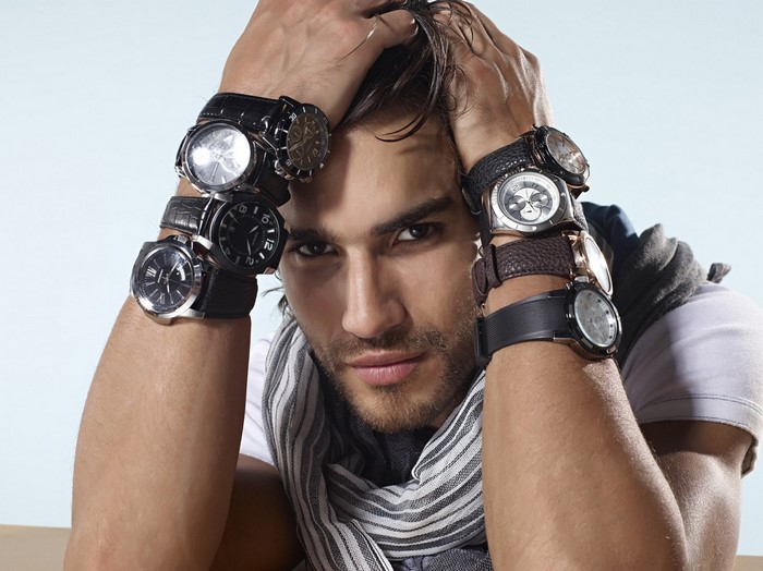 Man wearing multiple watches on his arms