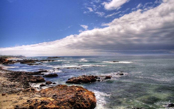 Rocky coastline with waves under a cloudy sky