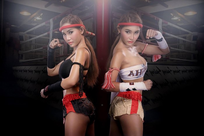Two Asian women in Muay Thai attire in a boxing ring