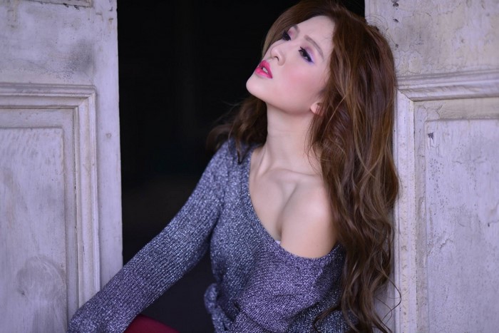 Asian woman with long brown hair wearing a silver sweater