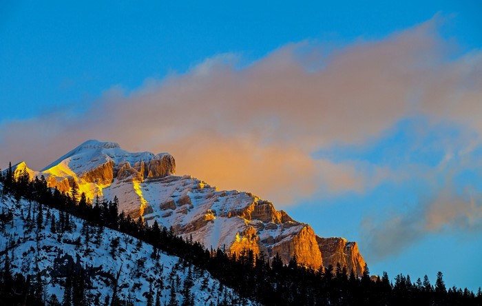 Snow-covered mountain peak illuminated by sunset