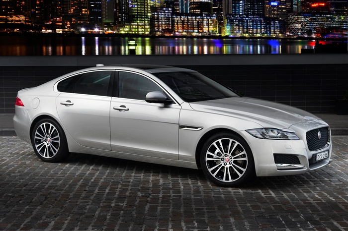 Silver Jaguar XF Portfolio sedan parked on cobblestone street