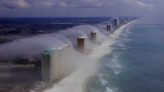 Fog rolling over buildings on a beach
