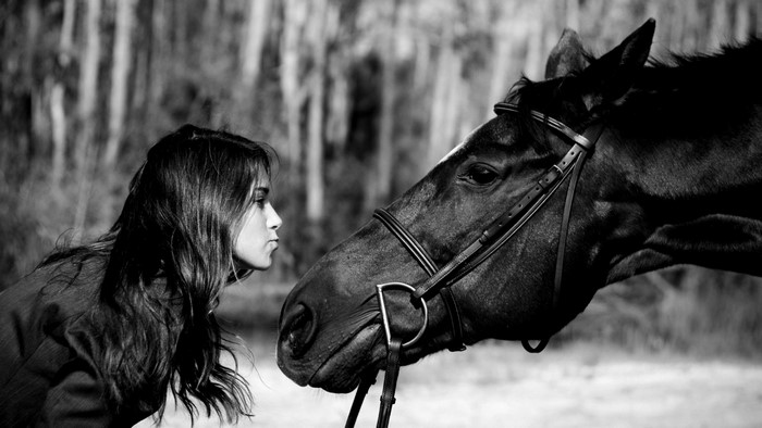 Girl kissing a horse in black and white