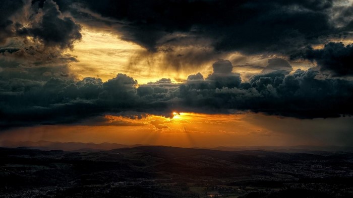 Dramatic Sunset with Dark Clouds and Sunlight Rays