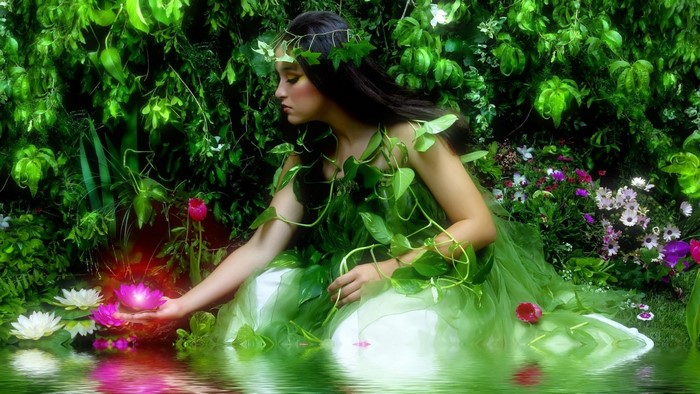 Woman in a green dress in a garden with flowers