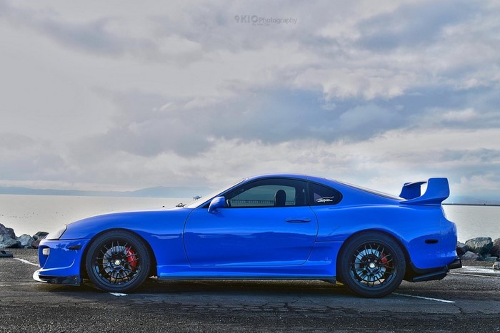 Blue Toyota Supra parked by the water
