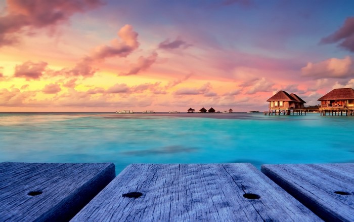 Overwater bungalows at sunset in the Maldives