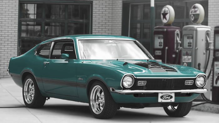 Teal Ford Maverick parked at a vintage gas station