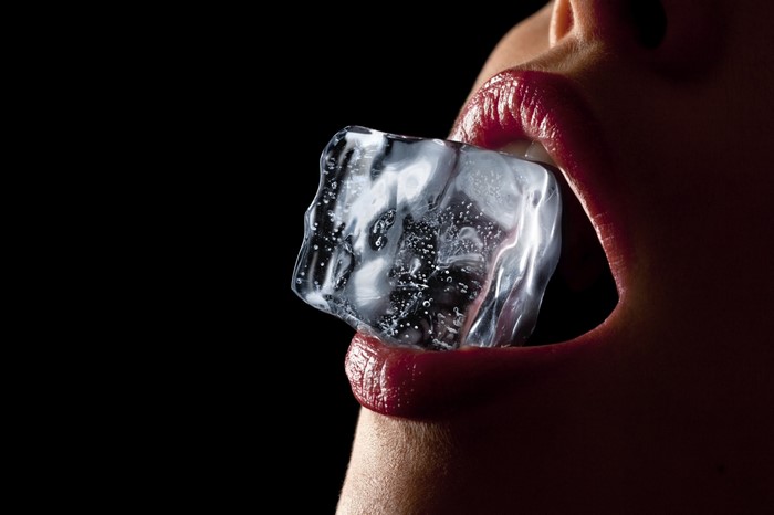 Woman with ice cube in mouth