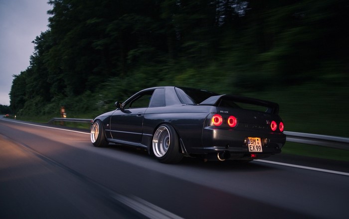 Nissan Skyline R32 GT-R driving on a road at dusk